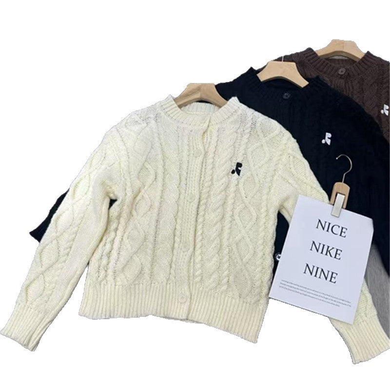 Women's chunky knit cardigan with elegant cable design and unique button details NOVAE