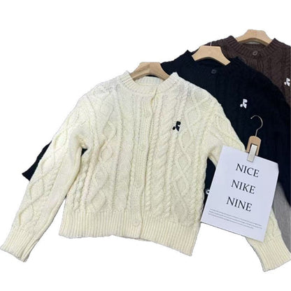 Women's chunky knit cardigan with elegant cable design and unique button details NOVAE